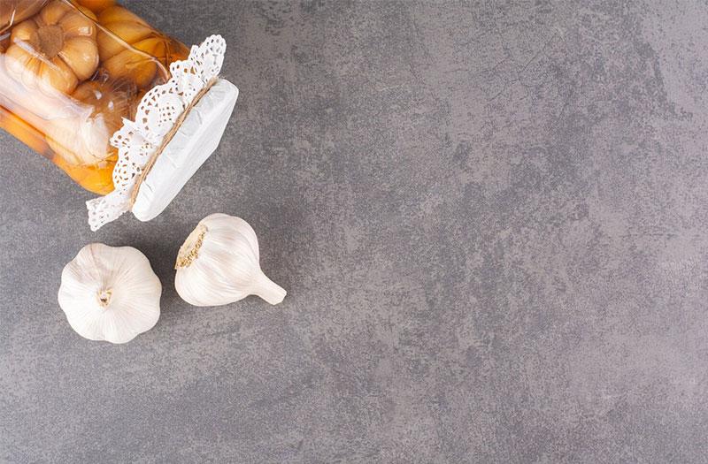 Nguyên liệu chuẩn bị làm tỏi ngâm mật ong tại nhà, bao gồm tỏi tươi bóc vỏ và mật ong nguyên chất.